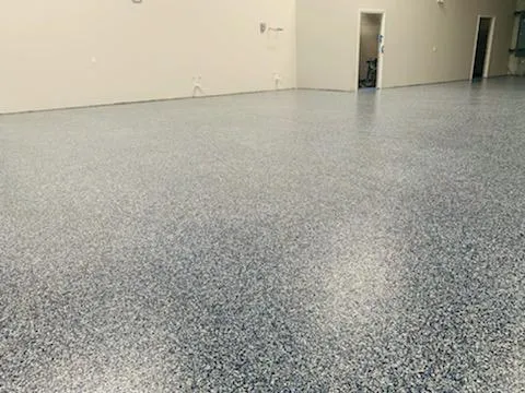 Grey decorative flake flooring extending down a bright commercial corridor